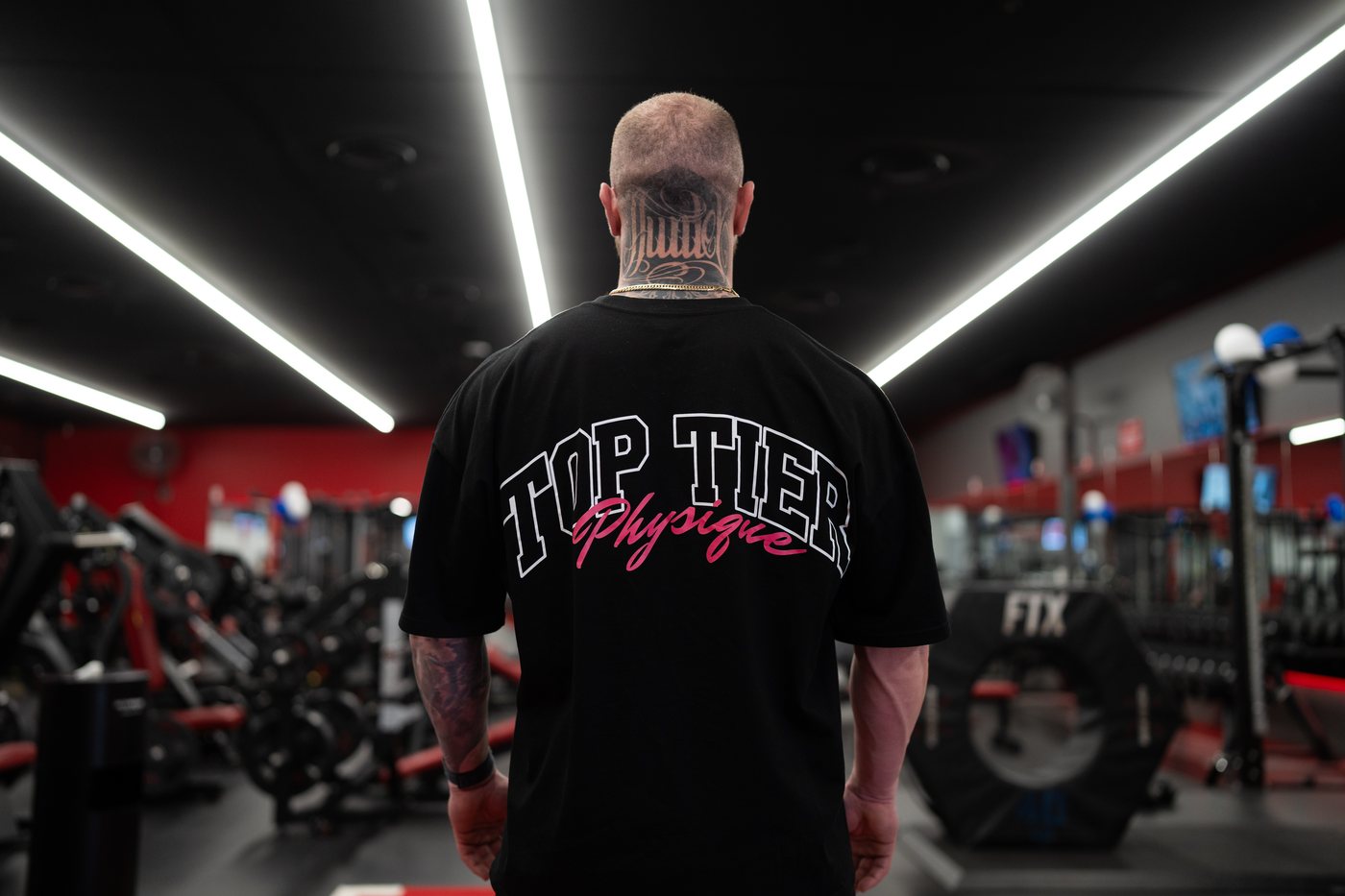 Grant Bourke wearing the Top Tier Physique tee, back print, on the Snap Fitness Campbelltown gym floor
