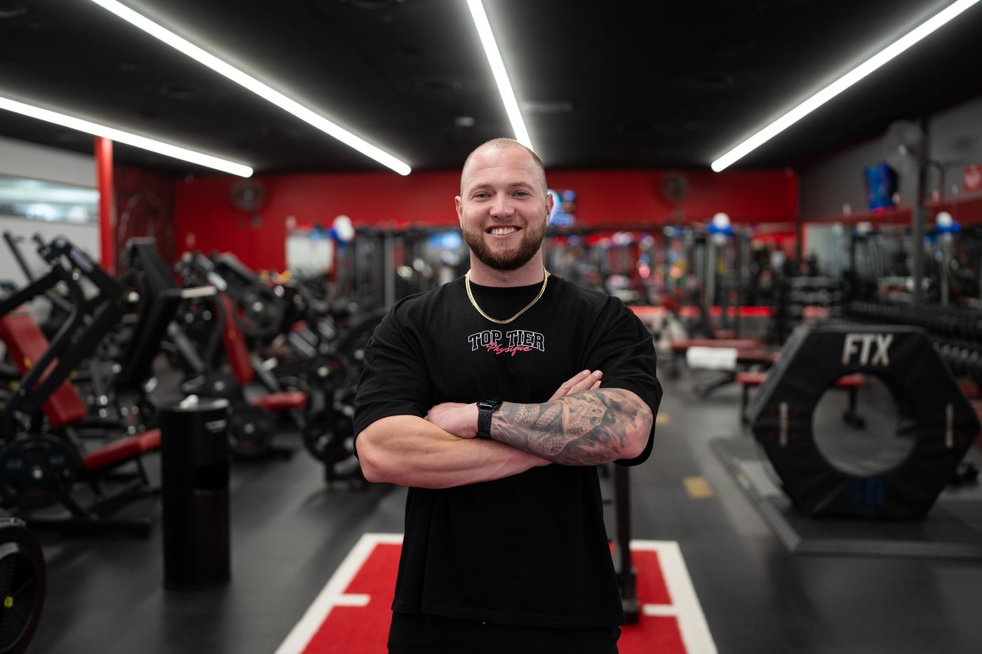 Grant Bourke wearing the Top Tier Physique tee, front print, on the Snap Fitness Campbelltown gym floor